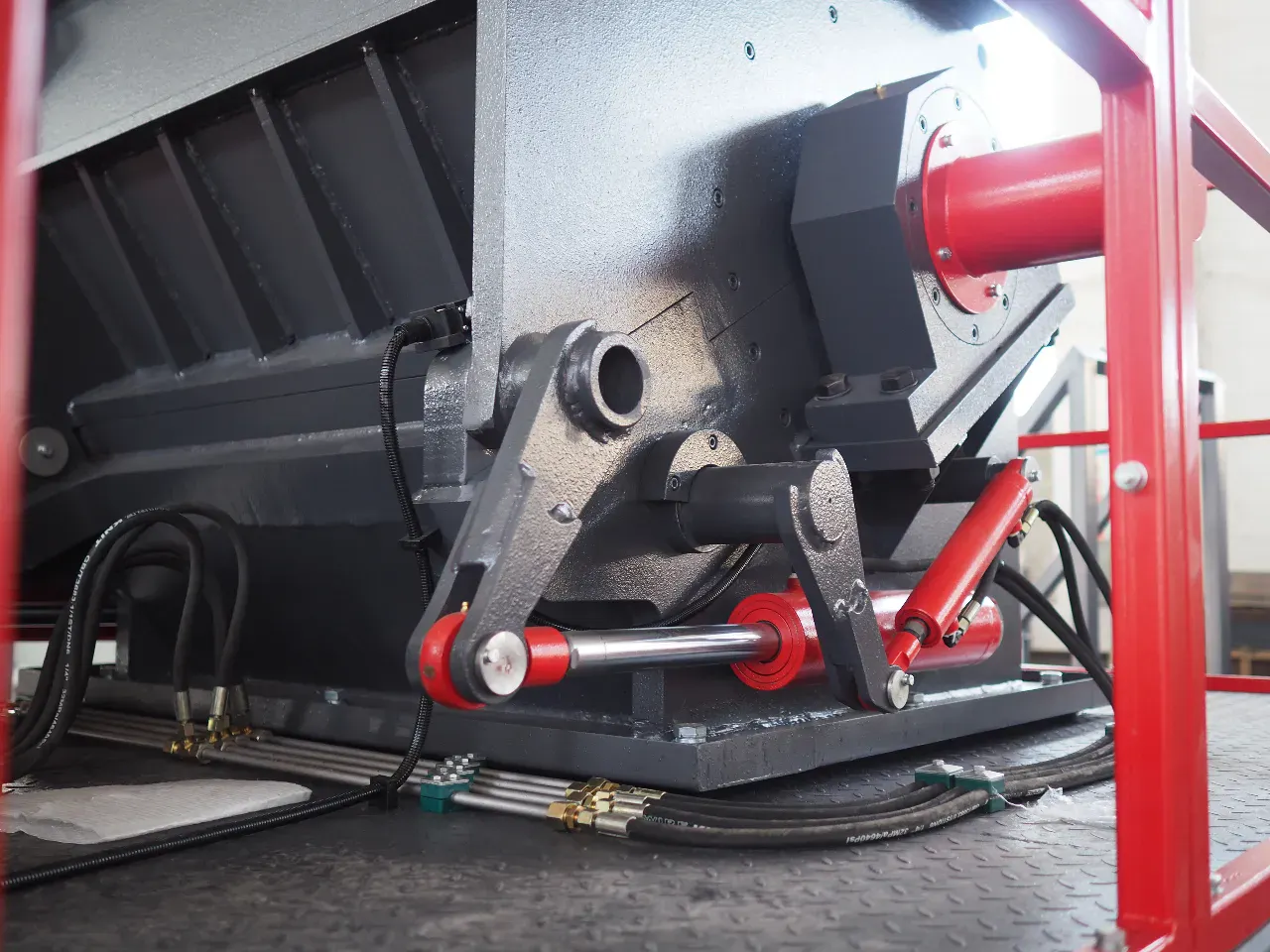 The hydraulic opening system of a heavy-duty plastic crusher, showing the powerful hydraulic cylinder used for easy access during maintenance.